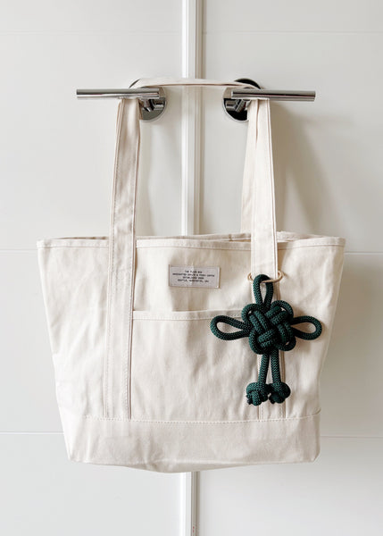 Traditional Chinese fortune knot in a deep emerald green color in a jumbo size, attached to a canvas tote bag.